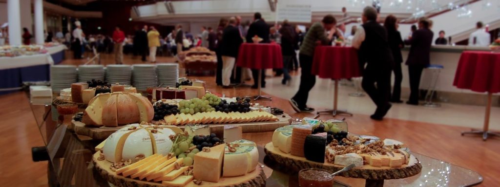 Table set with buffet food with people in the background at a networking event