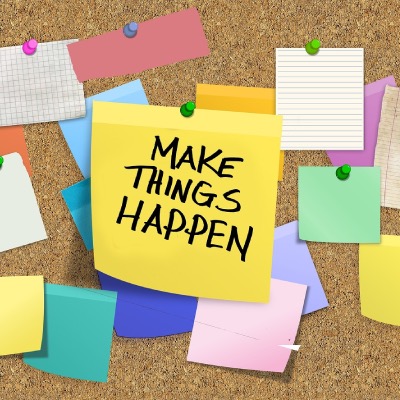 Bulletin board with notes covering it but with a central image saying Make Things Happen