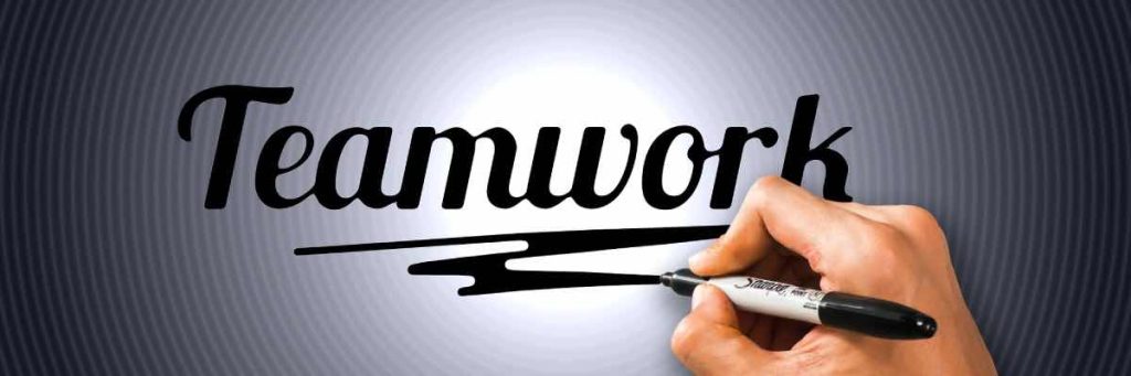 Banner image showing the pen in the hand of a person who has just written the word teamwork in relation to event management